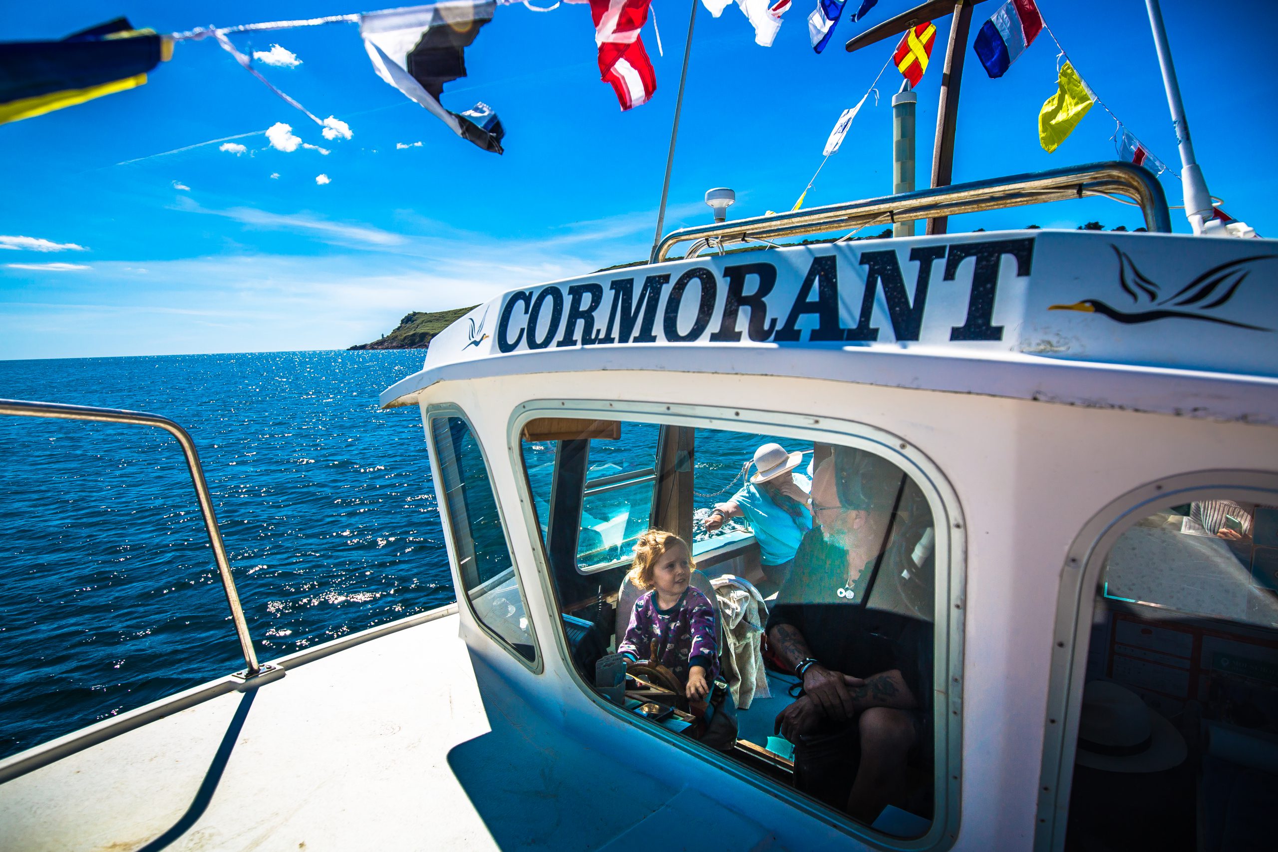 A young skipper takes the helm onboard The Cormorant.