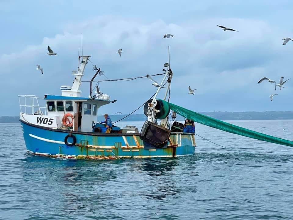 A fishing boat from Newlyn harbour laying out the fishing nets.